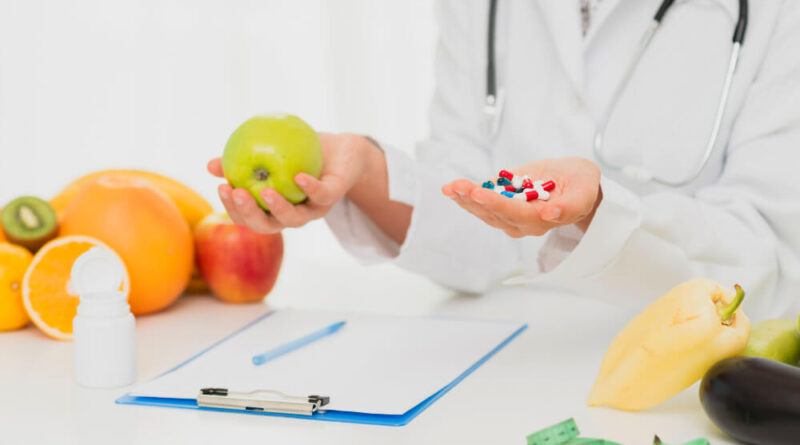 médico com pílulas e frutas - dieta HCG
