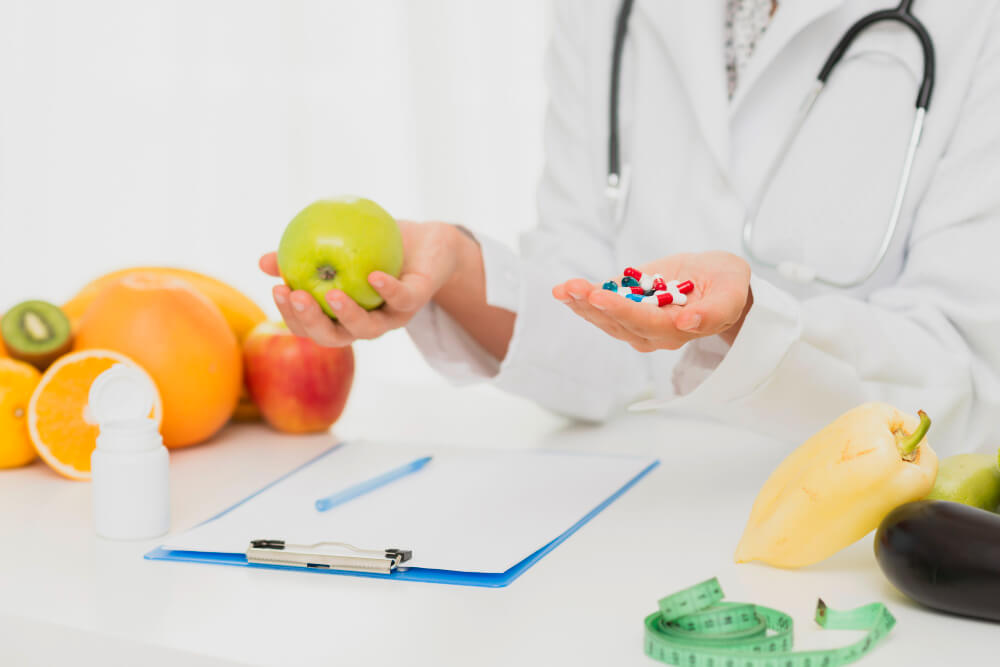médico com pílulas e frutas - dieta HCG