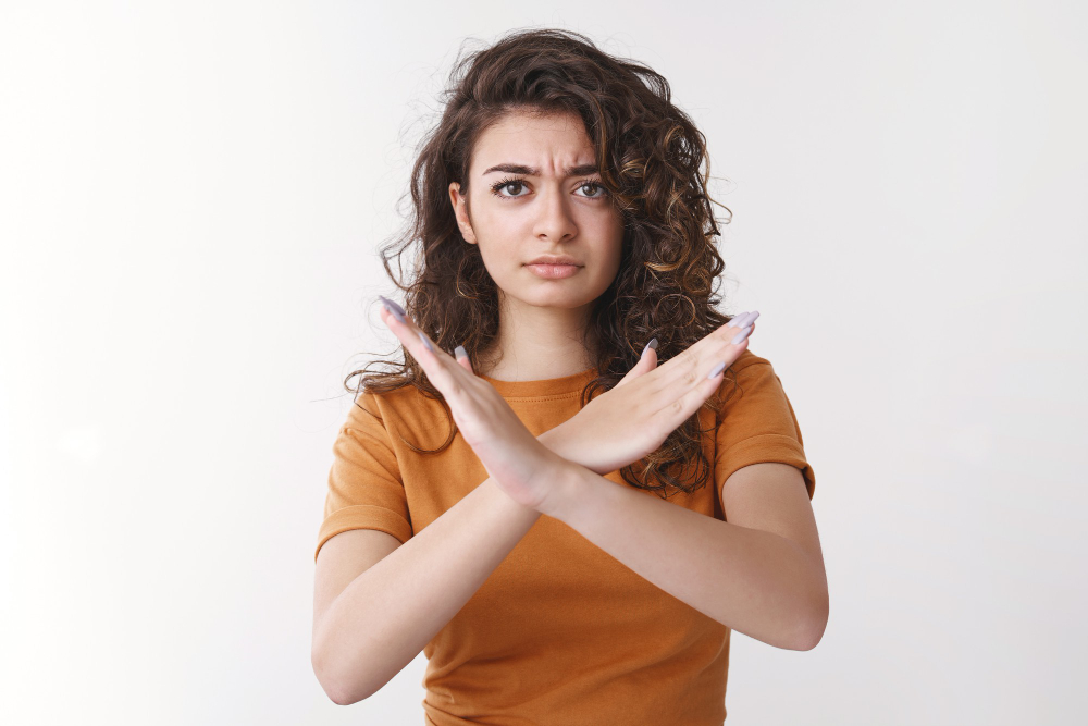 mulher com braços cruzados em forma de X simbolizando os erros ao cuidar da saúde