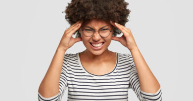 mulher com as mãos na cabeça representando o estresse crônico