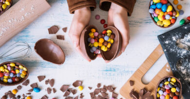 Como fazer ovo de páscoa Cacau Show em casa (passo a passo fácil) duas mãos segurando um ovo de chocolate com vários chocolates ao redor