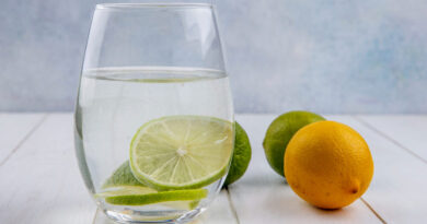 Água com limão em jejum faz bem? mitos e verdades explicados pela ciência Copo de água com limão em fatias sobre mesa clara, representando o consumo de água com limão em jejum