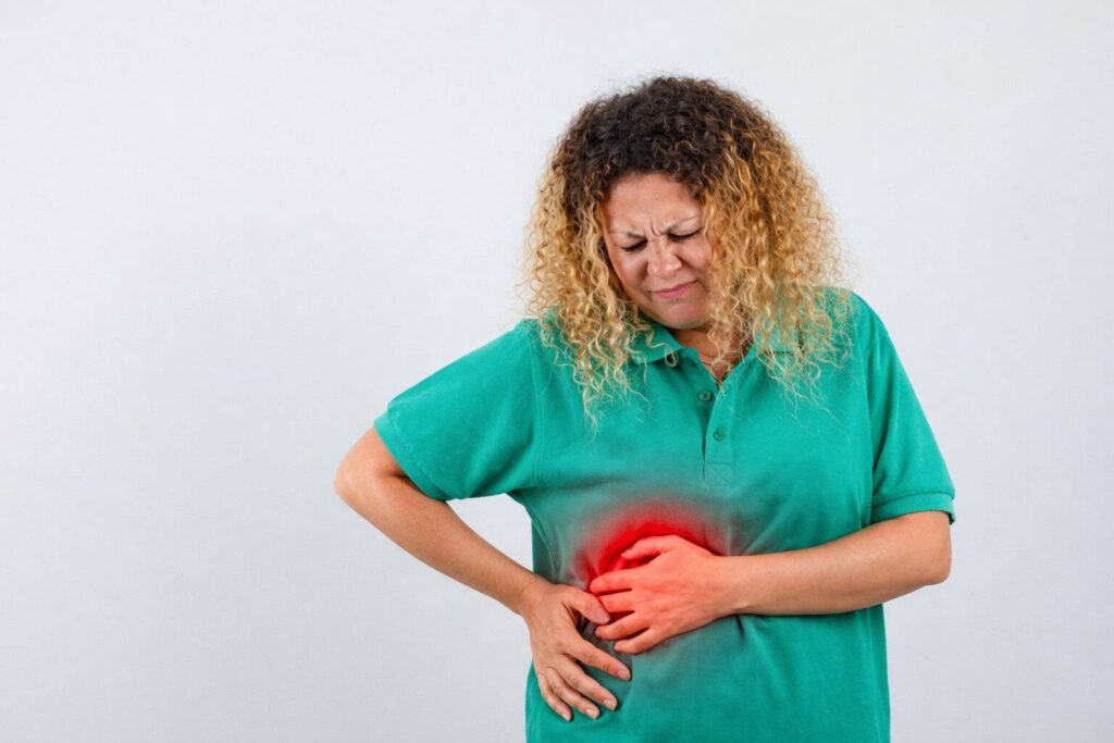 Mulher com desconforto abdominal no lado direito, possível relação com gordura no fígado sintomas