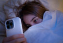 Celular antes de dormir: o hábito noturno que está destruindo seu sono mulher usando celular antes de dormir no quarto escuro prejudicando o sono