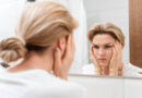 “Cortisol face”: a trend do TikTok sobre rosto inchado tem fundamento? Mulher observa o rosto no espelho com expressão de preocupação, em referência à trend “cortisol face” e ao inchaço facial.