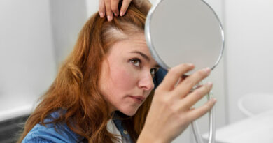 Cabelo caindo mais que o normal? Entenda os sinais de alerta e o que fazer Mulher observando falha no couro cabeludo com um espelho, sinal de cabelo caindo