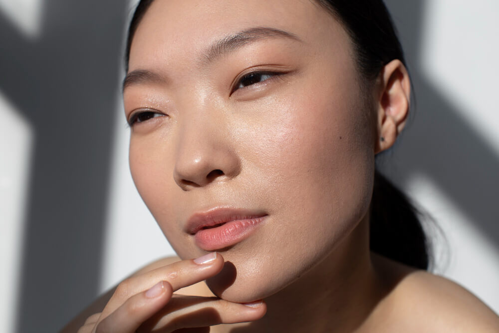 Mulher com pele luminosa e aparência hidratada, representando o efeito glass skin do skincare coreano