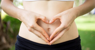 Saúde intestinal: como o seu intestino influencia todo o seu corpo Pessoa formando um coração com as mãos sobre o abdômen, representando cuidado com a saúde intestinal