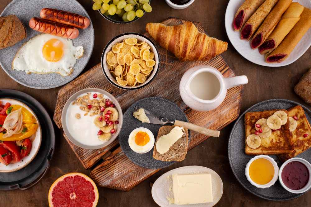 Mesa de café da manhã variado com ovo, iogurte com granola e pão, opções para um café da manhã rico em proteín