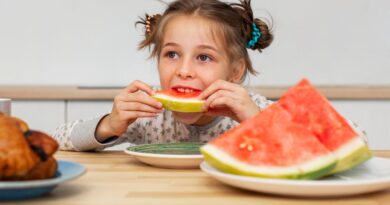 Lanche saudável para crianças: 7 ideias fáceis, rápidas e econômicas Criança comendo fatia de melancia, exemplo de lanche saudável para crianças