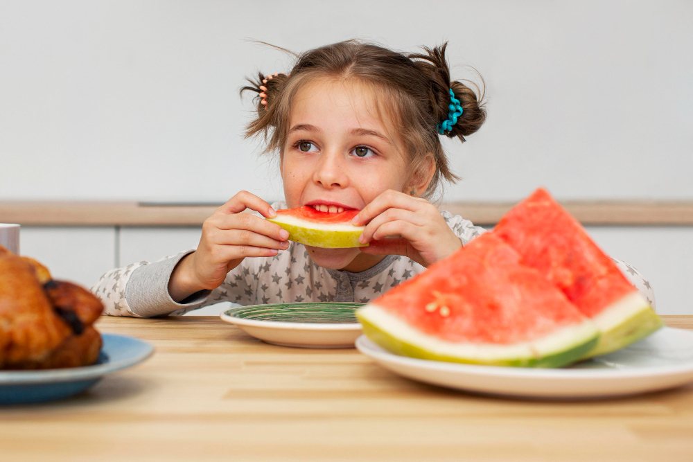 Criança comendo fatia de melancia, exemplo de lanche saudável para crianças