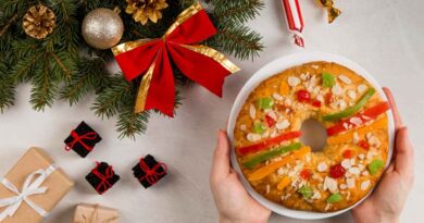Bolo de Natal fofinho e fácil: receita passo a passo Bolo de Natal em formato de coroa com frutas cristalizadas e amêndoas, servido em prato branco entre enfeites natalinos